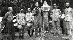 Amazônia, 1914: Theodore Roosevelt (apoiado no marco) e o coronel Cândido Mariano da Silva Rondon (à direita do marco, com as mãos nos bolsos da farda) [Reprodução]